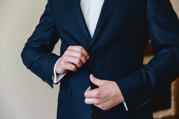 Reunión del novio, detalles, chaqueta, zapatos, relojes y botones en el día de la boda.