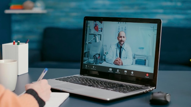 Reunión de una paciente con un médico en una consulta de videollamada en línea para preguntar sobre el tratamiento de enfermedades y la telemedicina de atención médica. Mujer enferma hablando con un médico en videoconferencia remota. De cerca.