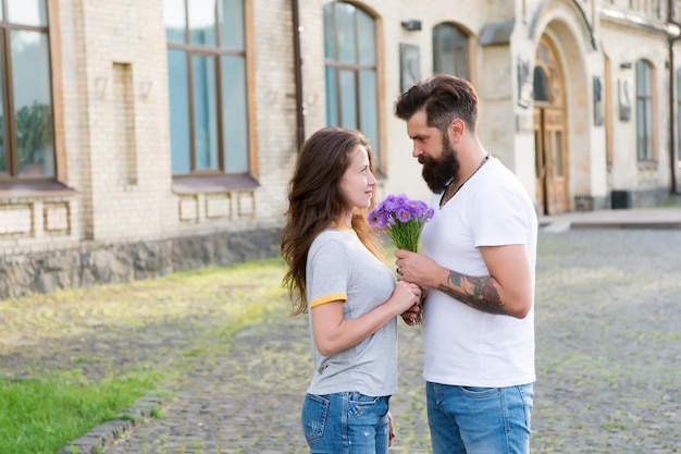 Reunión de pareja para cita Regalo de ramo Hombre dando ramo de flores Cita romántica Chico preparó ramo sorpresa para novia Sentimientos verdaderos Recoger chica para cita Hipster barbudo enamorarse