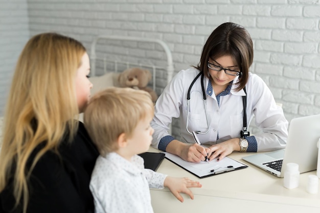 Reunión del pediatra con la madre y el niño en el hospital