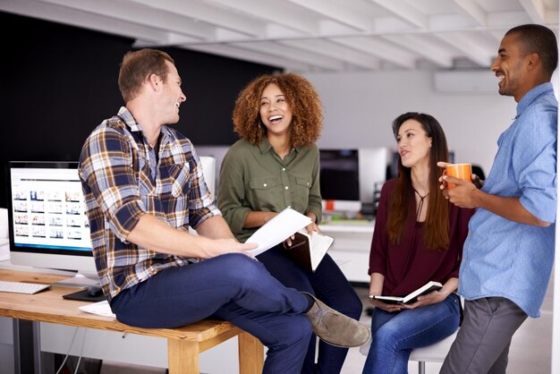 Reunión de risa del equipo y documentos en la oficina para planificar la estrategia y la felicidad con apoyo Gente de negocios del grupo y conversación cómica con hombres, mujeres y diversidad para amigos al inicio