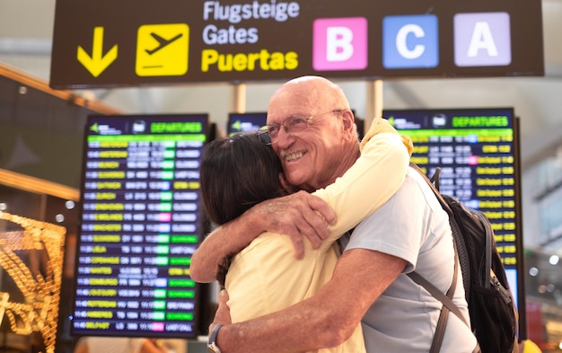 Foto reunión en la terminal del aeropuerto viaje familia pareja abrazo en el aeropuerto reunión y felicidad