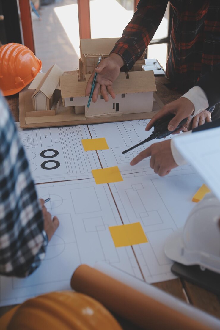 Foto reunión de trabajo en equipo de ingenieros trabajo de dibujo en una reunión de planos para un proyecto que trabaja con un socio en la construcción de modelos y herramientas de ingeniería en el lugar de trabajo concepto de construcción y estructura