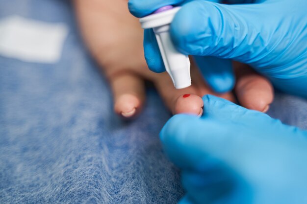 Revisión de salud. Cerca del paciente que pone la mano sobre la mesa mientras visita al médico en el laboratorio