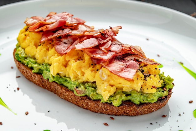 Revuelto sobre tostadas con tocino guacamole y aceitunas