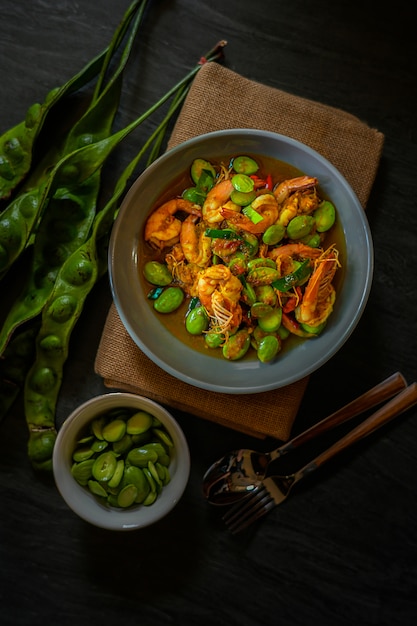 Revuelva el curry rojo frito con camarones y frijoles amargos