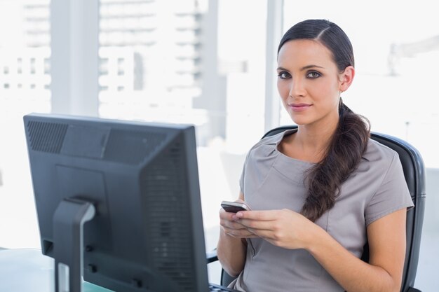 Rexled haired haired businesswoman sending message