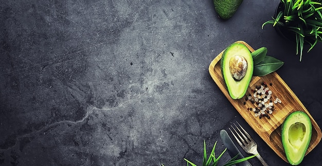 Rezepte zum Kochen mit Avocado. Reife grüne Avocado auf einem Holzbrett zum Servieren.