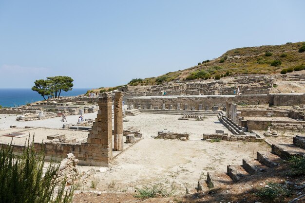 RHODES, GRÉCIA, - 11 de agosto de 2015: Pessoas explorando ruínas da antiga cidade de Kamiros na ilha de Rodes, Grécia