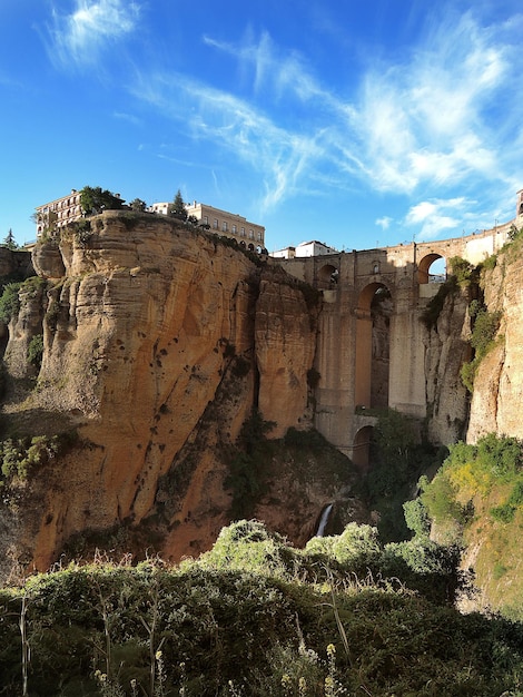 Foto rhonda. spanien. andalusien. blick von unten auf die brücke von puento nuevo. vertikales foto. stadtbild von ronda im sommer