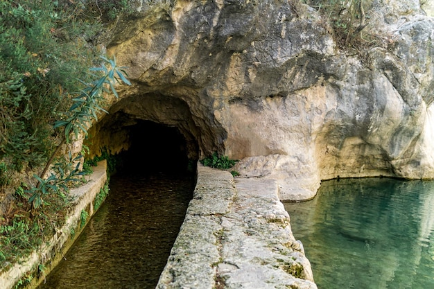 Riachuelo artificial en un canalón de piedra bajo la roca en zona montañosa