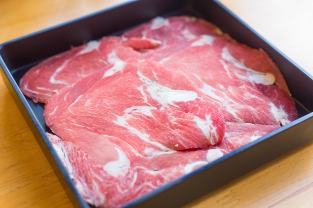 Rib eye es carne de res fresca cortada en rodajas crudas que se sirvió para Sukiyaki, carne de res a la parrilla, restaurante Shabu Yakiniku