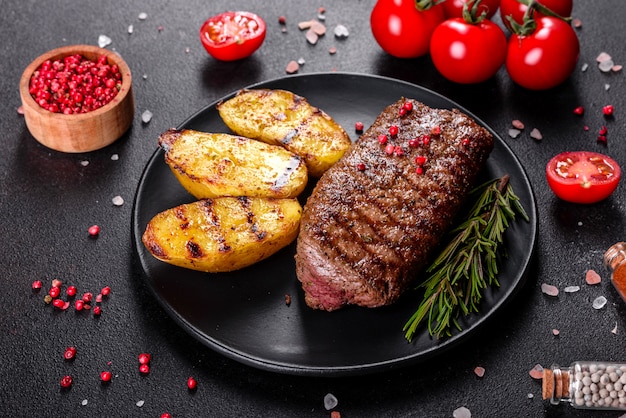 Ribeye-Steak mit Kartoffeln, Zwiebeln und Kirschtomaten. Saftiges Steak mit aromatisierter Butter