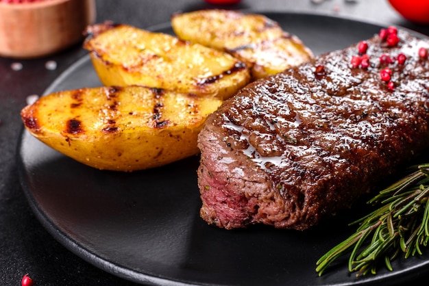 Ribeye-Steak mit Kartoffeln, Zwiebeln und Kirschtomaten. Saftiges Steak mit aromatisierter Butter