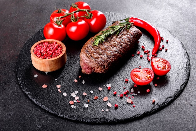 Ribeye-Steak mit Kartoffeln, Zwiebeln und Kirschtomaten. Saftiges Steak mit aromatisierter Butter