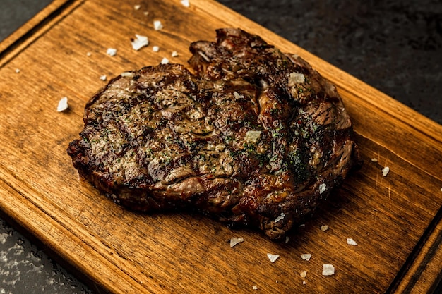 Ribeye-Steak ohne Knochen, serviert auf einem Holzbrett in einem Restaurant