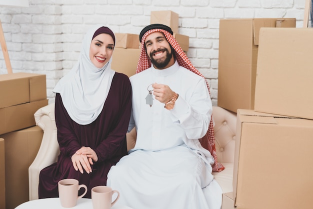 Rich arab home buyers in der nähe von packed boxes housing.