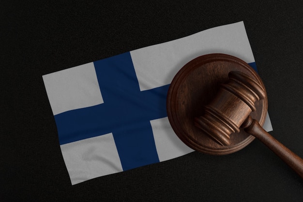 Richter Hammer und die Flagge von Finnland. Recht und Gerechtigkeit. Verfassungsrecht.
