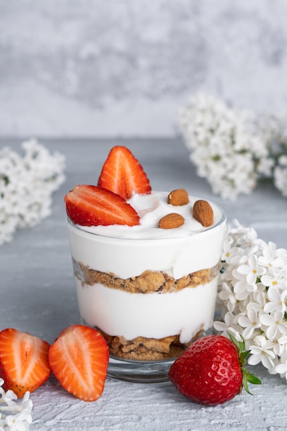 Ricotta-Dessert mit frischen Erdbeeren. Gesundes Frühstück mit Joghurt, Erdbeeren und Mandeln