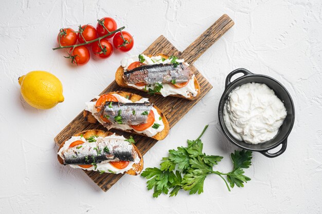 Ricotta-Sardinen-Toast-Set, auf weißem Steintischhintergrund, Draufsicht flach