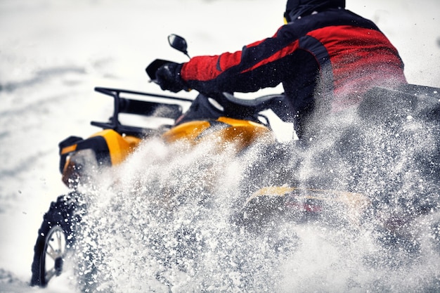 Foto rider conduciendo en la carrera de quad en invierno en el bosque