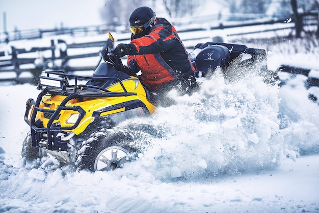 Rider conduciendo en la carrera de quad en invierno en el bosque