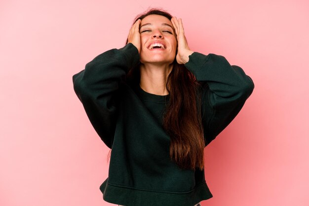 Se ríe con alegría manteniendo las manos en la cabeza Concepto de felicidad