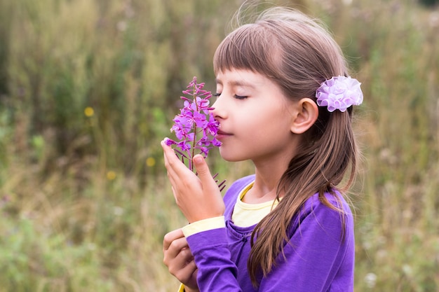 Riechende Blume des zehnjährigen Mädchens