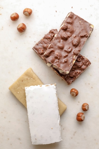 Riegel süßer Schokoladennougat mit Walnüssen auf einem weißen Tisch