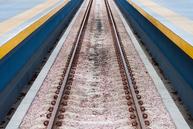 Rieles de tren de ferrocarril de línea recta y larga en el medio de la foto.