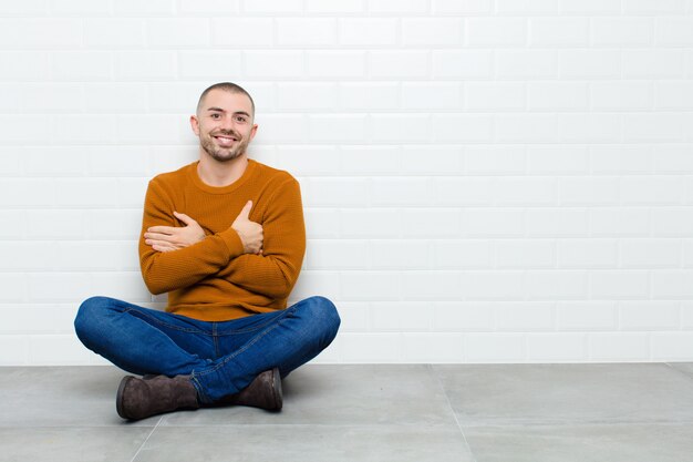 riendo alegremente con los brazos cruzados, con una pose relajada, positiva y satisfecha