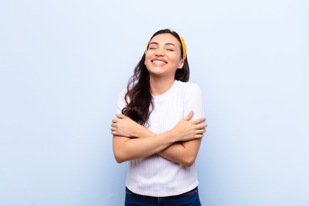 riendo alegremente con los brazos cruzados, con una pose relajada, positiva y satisfecha