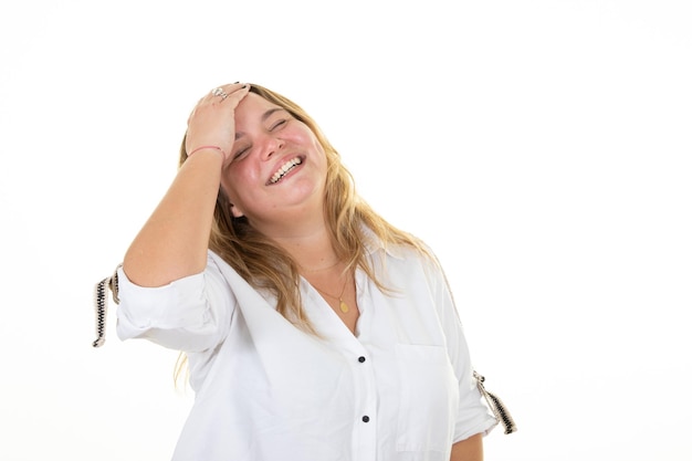 Riendo diversión rubia mujer de gran tamaño mano dedo en el cabello sonriendo feliz sobre fondo blanco.