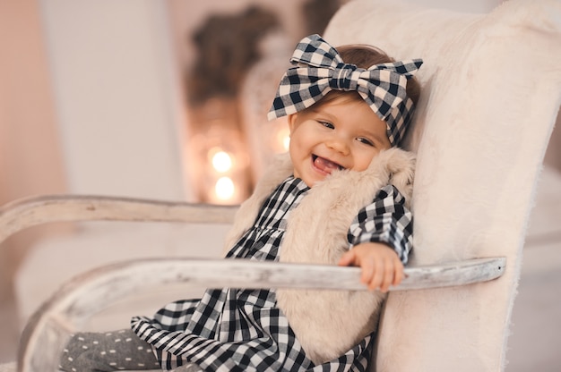 Riendo, elegante, niña, sentarse en una silla, encima, luces de navidad