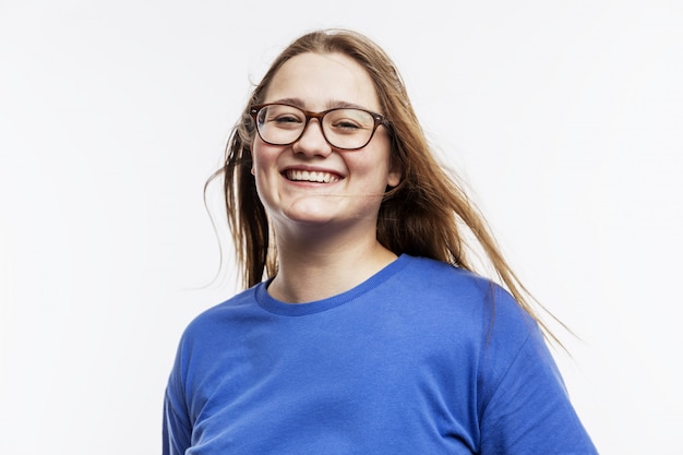 Riendo a gorda joven con gafas en una camiseta azul.