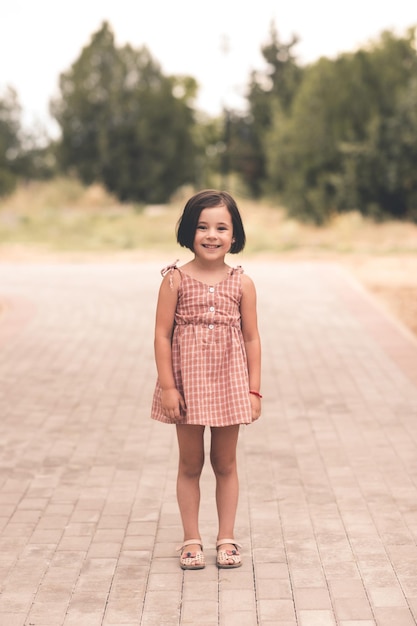 Riendo a niña linda niño feliz con vestido de moda