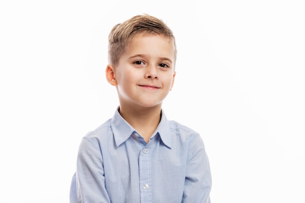 Riendo el niño en edad escolar con cambio de dientes delanteros en una camisa azul. Aislado en blanco