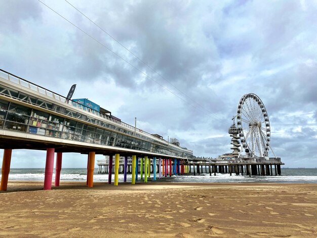 Foto riesenrad am strand gegen bewölkten himmel