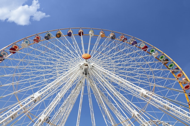 Riesenrad herein einen Vergnügungspark gegen blauen Himmel