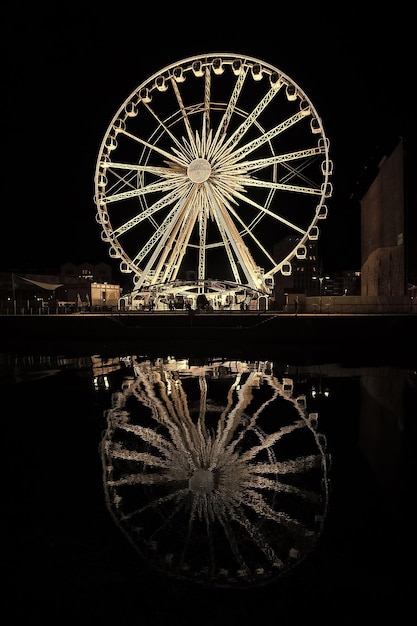 Riesenrad in Danzig Polen bei Nacht Vergnügungsattraktion mit Beleuchtung und Spiegelung im dunklen Wasser Sightseeing und Reisen Urlaub und Fernweh