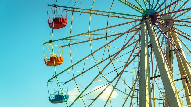 Riesenrad mit bunten Kabinen auf dem Hintergrund des blauen Himmels