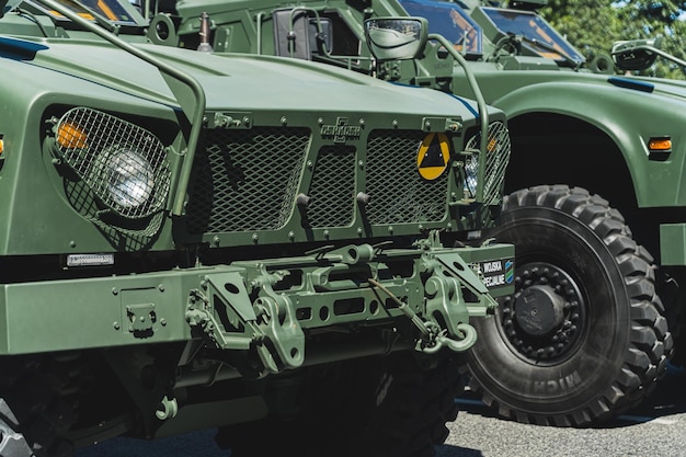 Riesige Motorhaube und Scheinwerfer eines modernen Militärfahrzeugs aus dunkelgrün gefärbtem Metall im Freien