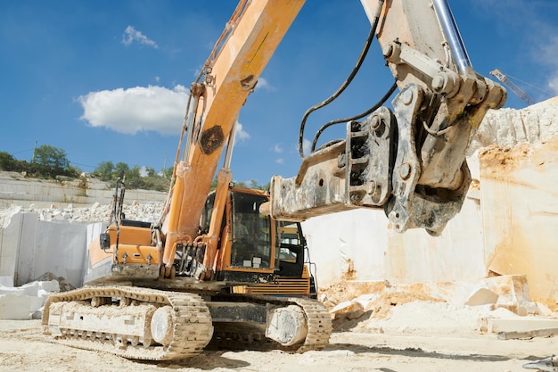 Riesige Raupenbaumaschine mit Greifer, die am Marmorsteinbruch arbeitet