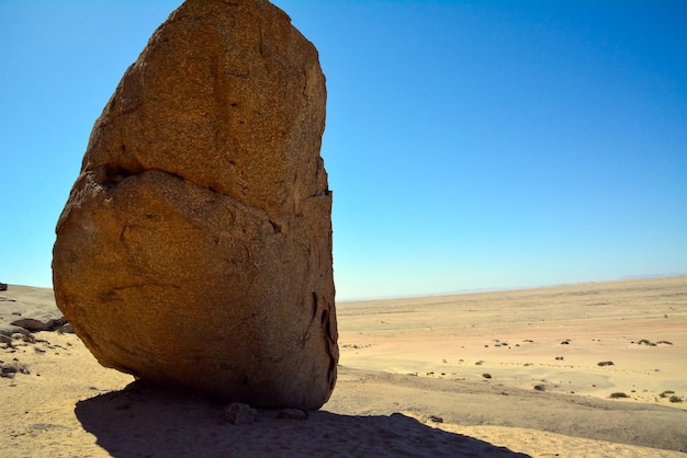 Riesige Steinblöcke liegen in der strahlenden Sonne im Sand der Wüste