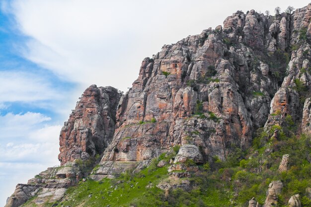 Riesige Steine mit Moos und Bäumen am Berghang