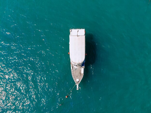 Riesige weiße Yacht segelt allein über das tiefblaue Meer, Draufsicht