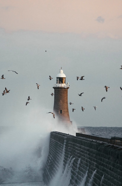 Foto riesige welle trifft auf einen leuchtturm in schottland