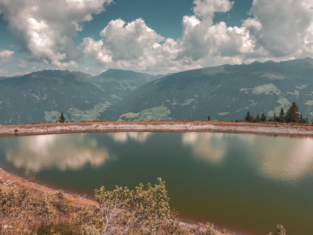 Riesiger blauer Bergsee, unberührte Tierwelt Europas, majestätische Berge, die mit Bäumen bedeckt sind, erheben sich über