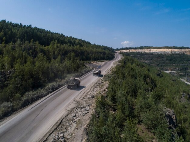 Riesiger industrieller Muldenkipper in einem Steinbruch, der Marmor oder Granit transportiert, der von einer Drohne geschossen wird