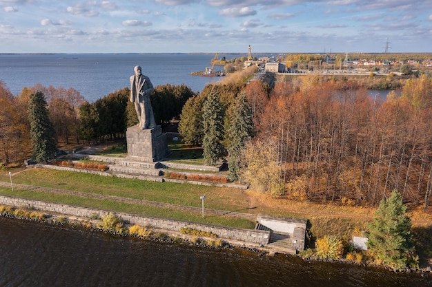 Riesiges Lenin-Denkmal umgeben von Bäumen am Ufer des Flusses in der Nähe des Wasserkraftwerks Dubna Russland